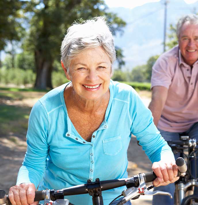 Elderly couple enjoying a bike ride with improved mobility from chiropractic