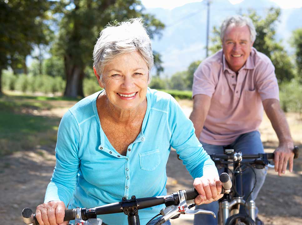 Elderly couple enjoying a bike ride with improved mobility from chiropractic
