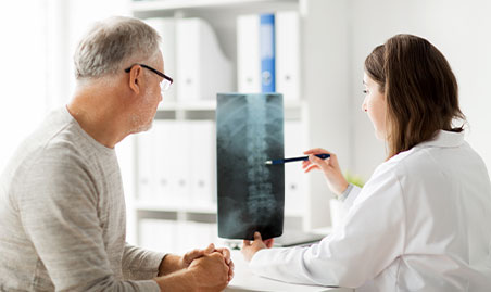 Chiropractor examines x-ray of herniated disc