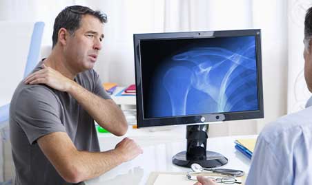 Chiropractor examines shoulder joint for cause of shoulder pain